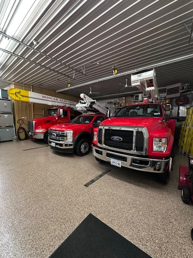Garage with work trucks parked on a tan flake floor — Central New York