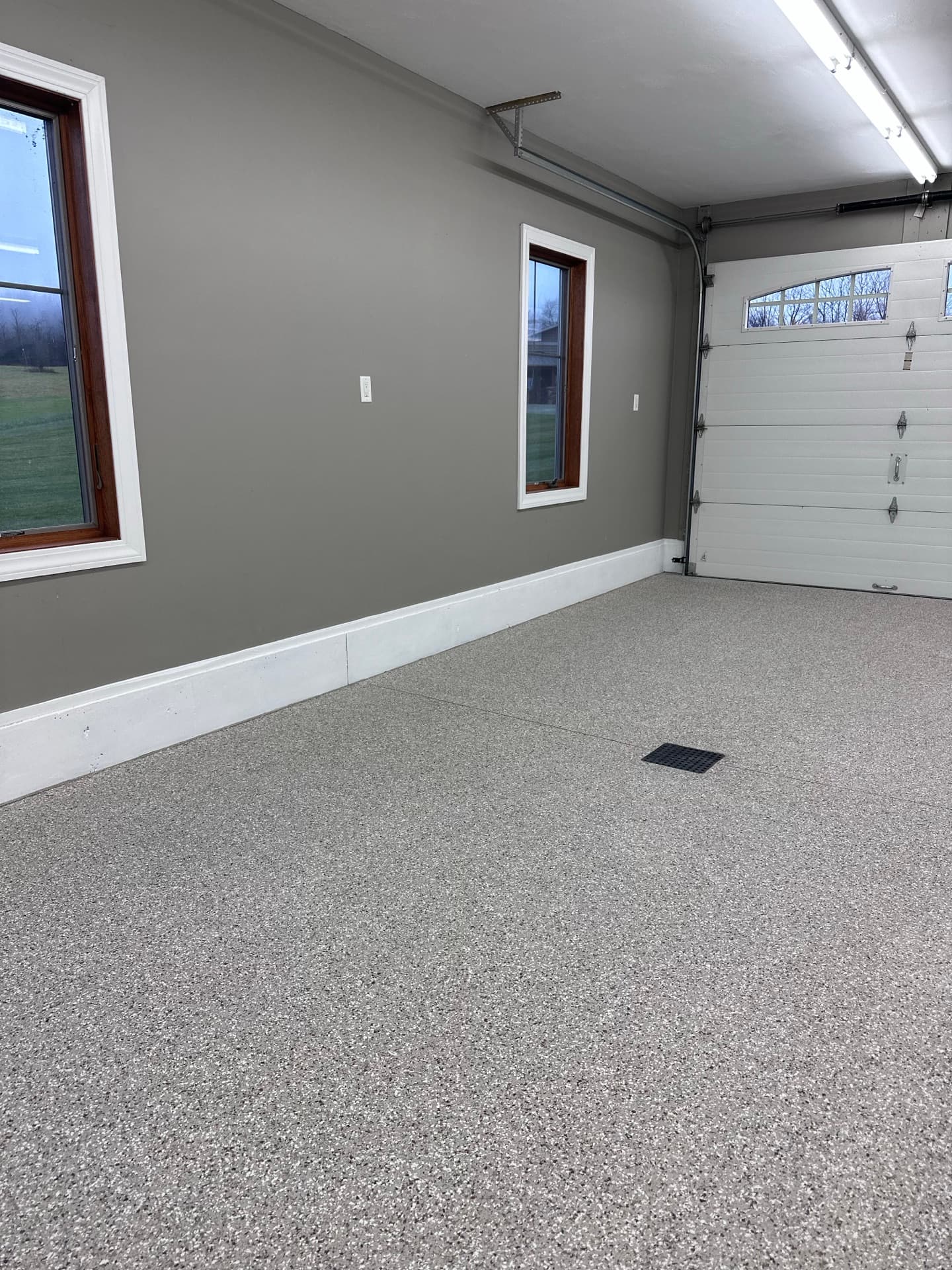 Finished tan and brown flake garage floor with a floor drain, Central New York